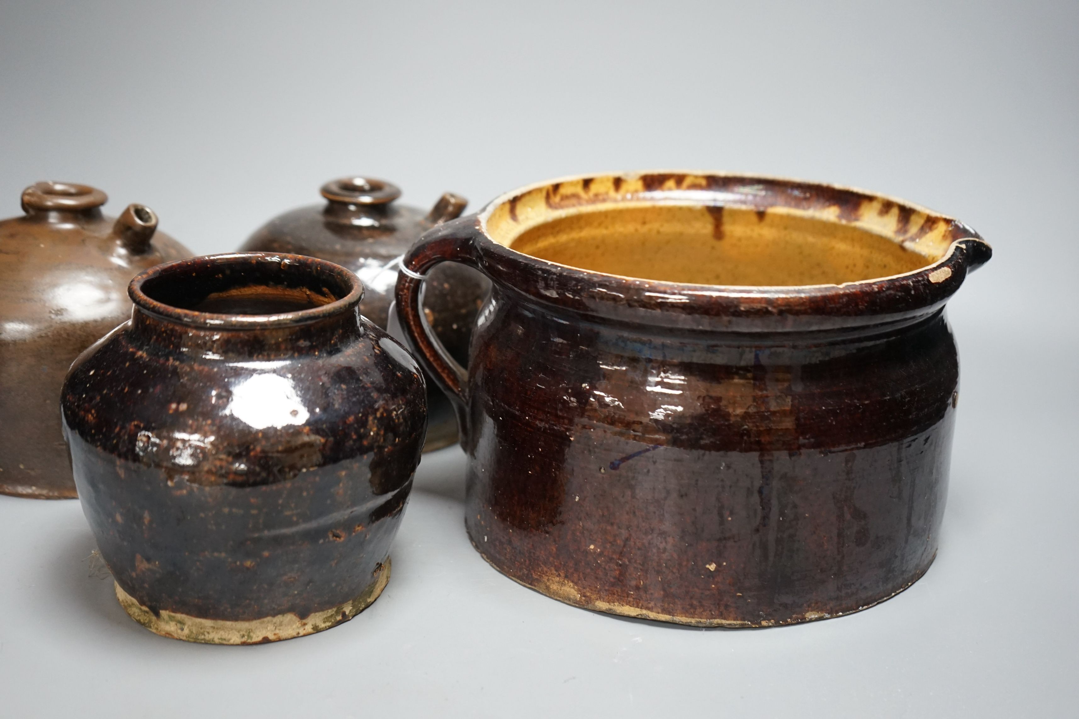 Two 19th century Chinese tenmoku glazed soy sauce jars, a similar jar and a pouring vessel, largest 14cm tall